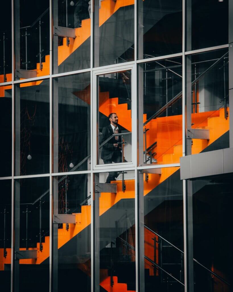 man walking up the stairs in office building